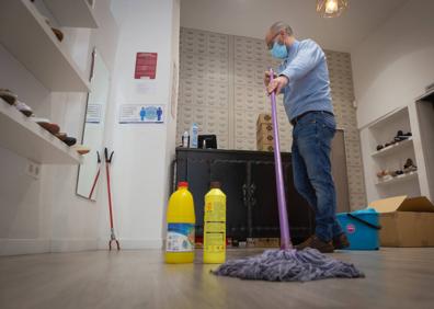 Imagen secundaria 1 - Arriba, José Manuel levanta la persiana como volverá a hacerlo mañana. Debajo, Gabriel con la fregona en Calzados Rosa Maciá, de Acera del Darro, y Toñi limpiando escaparates en Zacatín.