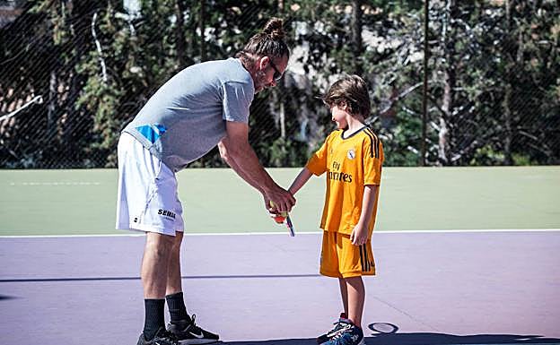 Un monitor corrige la postura a uno de los niños de la escuela durante un entrenamiento. 