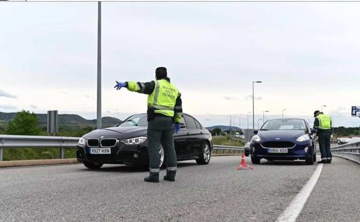Dos guardias civiles hacen indicaciones a los conductores en un control de tráfico