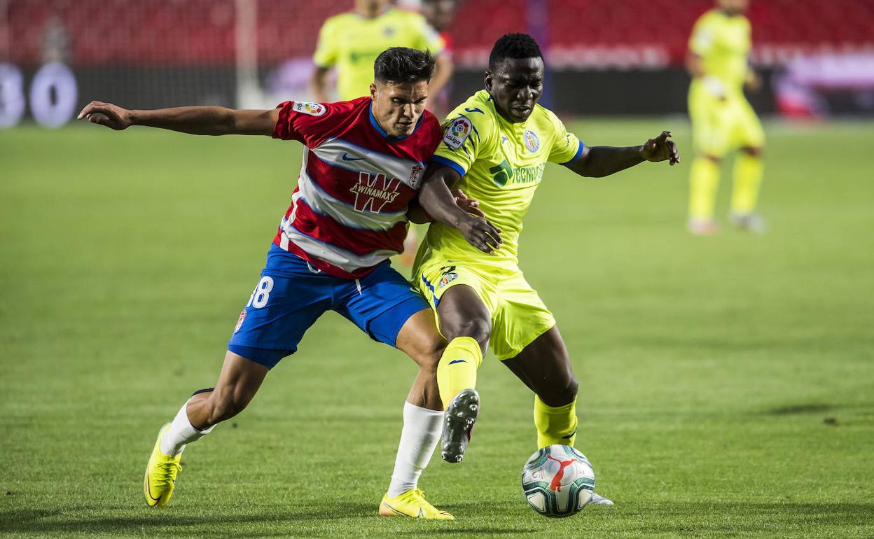 Antoñín, que debutó en Primera división en la segunda mitad, pugna por un balón con Djené. 