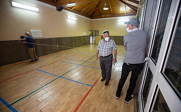 Vecinos del Zaidín miden el local que les ha cedido el Ayuntamiento para ubicar el banco de alimentos.