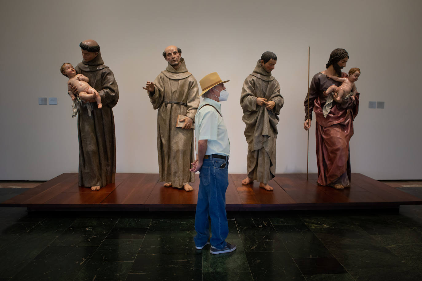 Visitante junto a un conjunto escultórico con tallas de Alonso Cano y Pedro de Mena.