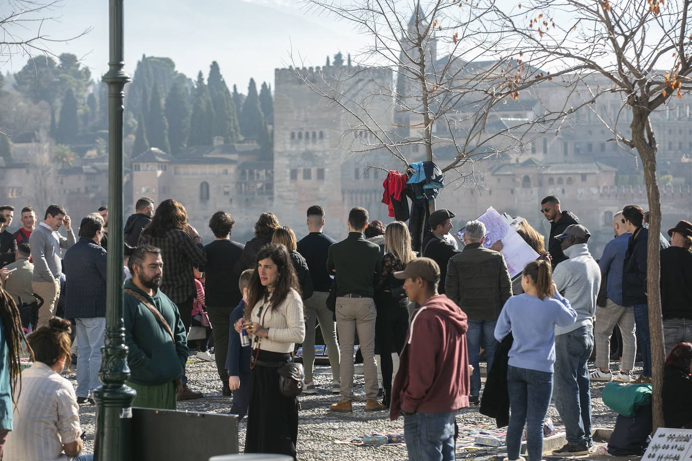 Turistas se amontonan en el mirador de San Nicolás para ver la Alhambra desde el Albaicín.