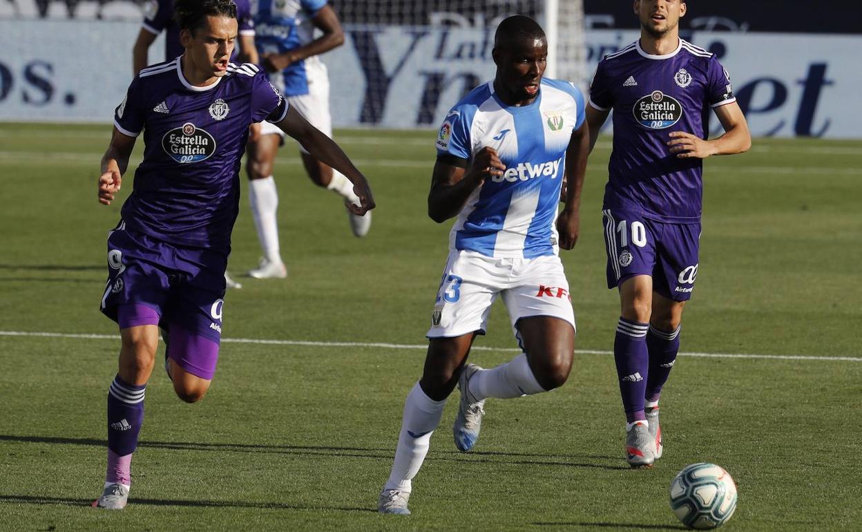 Amadou conduce el balón ante la presión de dos futbolistas del Valladolid. 