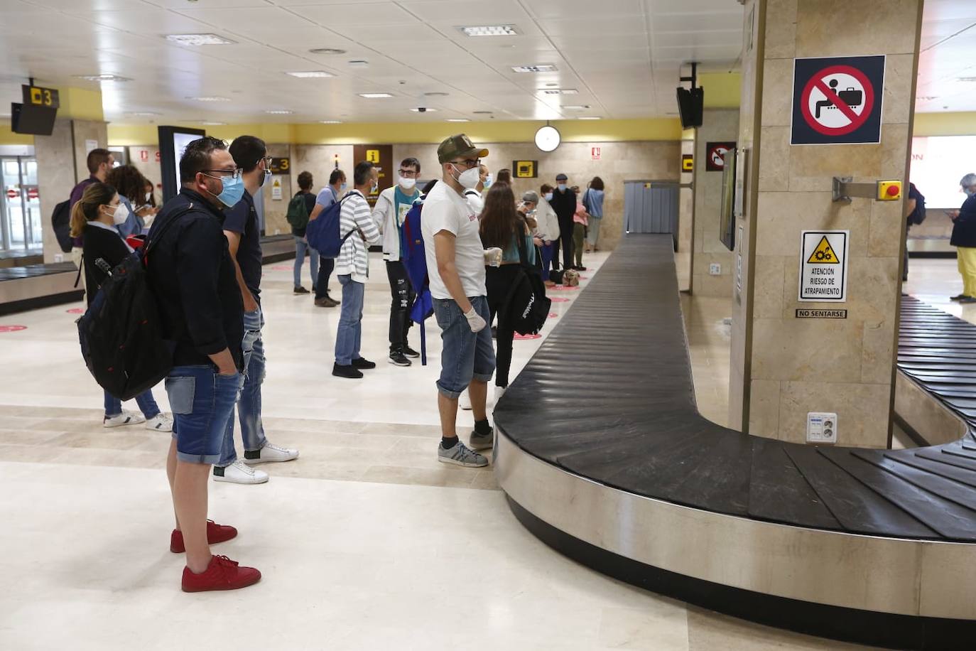Pasajeros de la ruta Granada-Barcelona esperando a recoger sus maletas. 