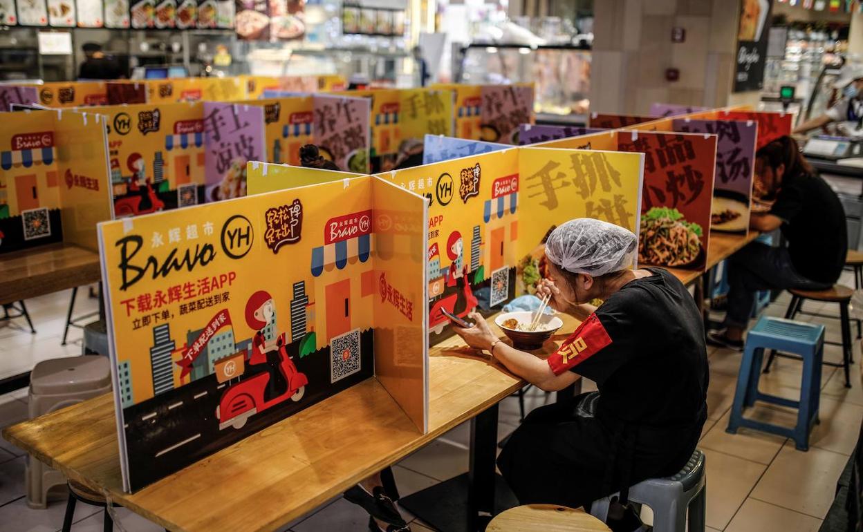 Dos mujeres comen en un restaurante con las medidas de distancia. 