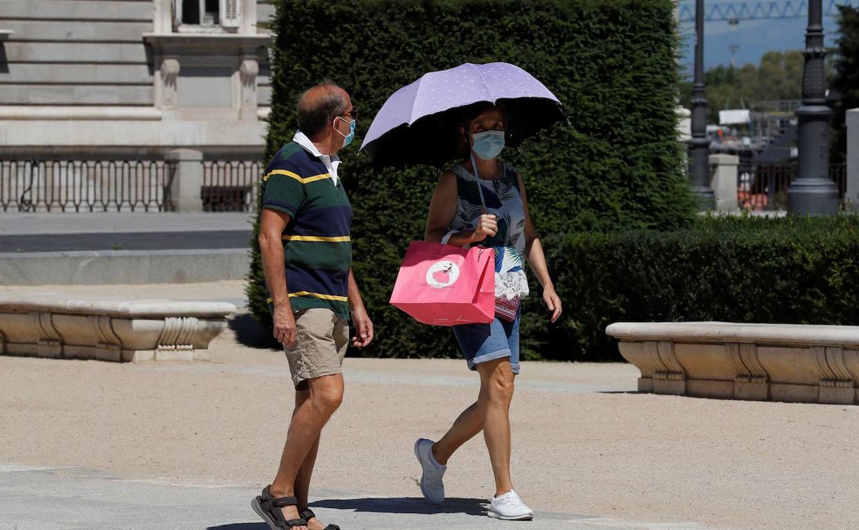 Dos personas pasean por el centro de Madrid bajo un fuerte calor. 