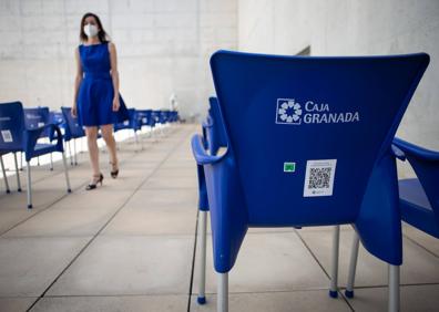 Imagen secundaria 1 - Arriba, dispensador de hidrogel. Abajo, sillas numeradas y localizadas con códigos QR, y señalización en pared.