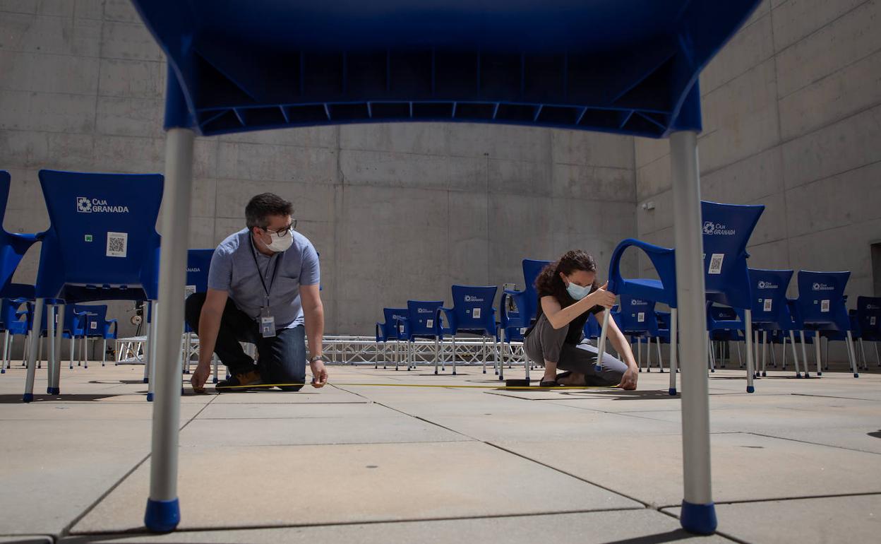 Operarios de CajaGranada Fundación midiendo ayer la distancia entre los asientos.