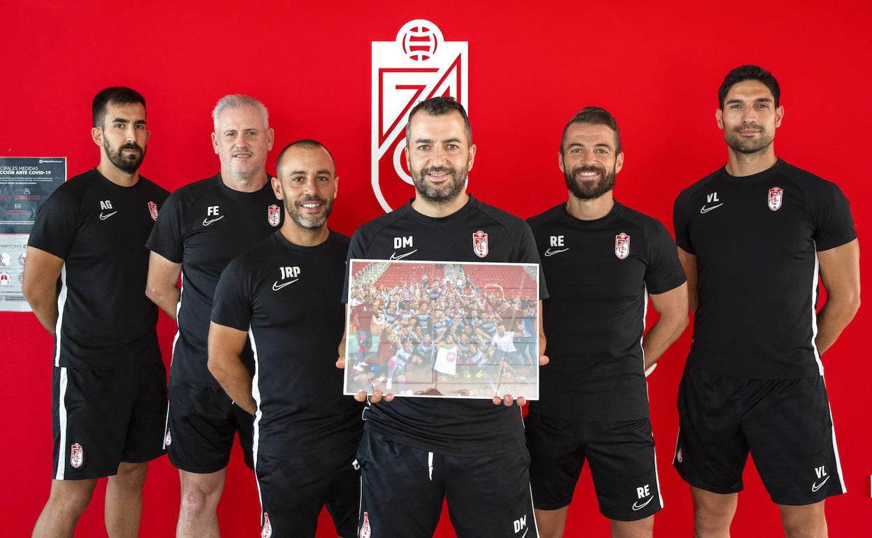 Álvaro García, analista; Juan Carlos 'El Pescao' Fernández, preparador de porteros; Jesús Roche, analista; Diego Martínez y su segundo Raúl Espínola; y el preparador físico Víctor Lafuente posan junto a una fotografía de Ramón L. Pérez para IDEAL del ascenso en Mallorca antes del último entrenamiento del equipo. 