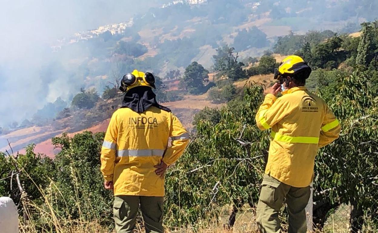 Dos bomberos del Infoca observan la evolución del fuego.