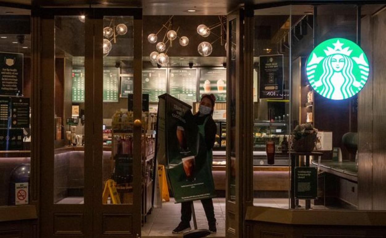 Una trabajadora de Starbucks con mascarilla recoge el bar en Melbourne, Australia, el pasado 5 de agosto. 