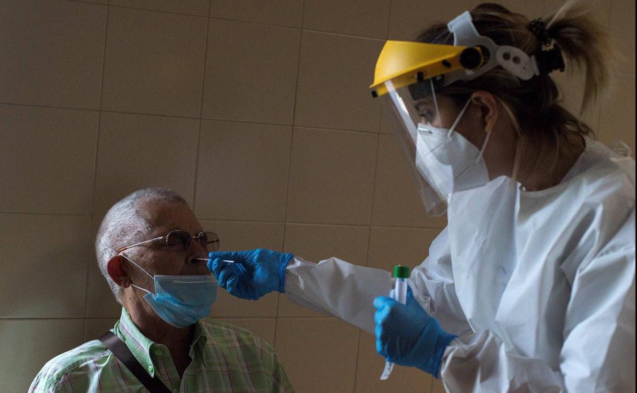 Imagen de archivo de una profesional sanitaria realizando una PCR a un vecino para un rastreo de contactos.