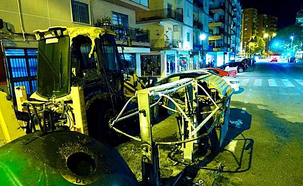 Contenedor quemado en calle Palencia junto a una excavadora afectada por el fuego también.