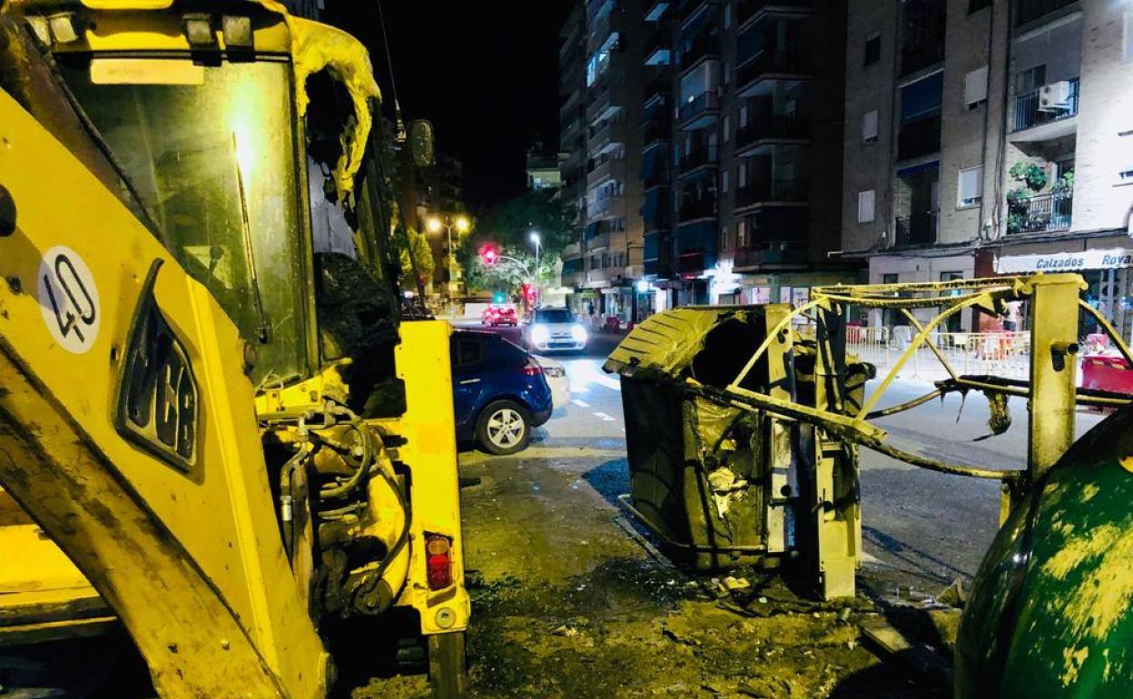 Contenedores quemados y la excavadora dañada por el fuego en la calle Palencia. 