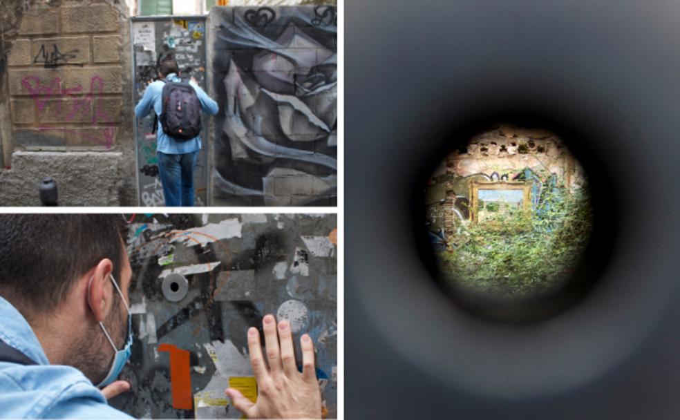 Un vecino se asoma por la mirilla del solar ubicado en el barrio de la Virgen, donde se esconde esta obra de arte.