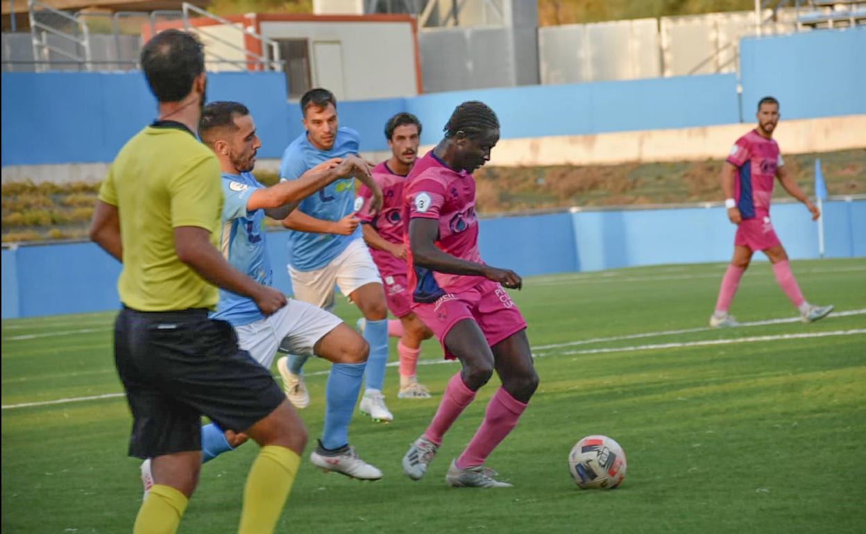 El lateral derecho Neto con la pelota en Lucena, con Jonathan Rosales al fondo de la imagen. 