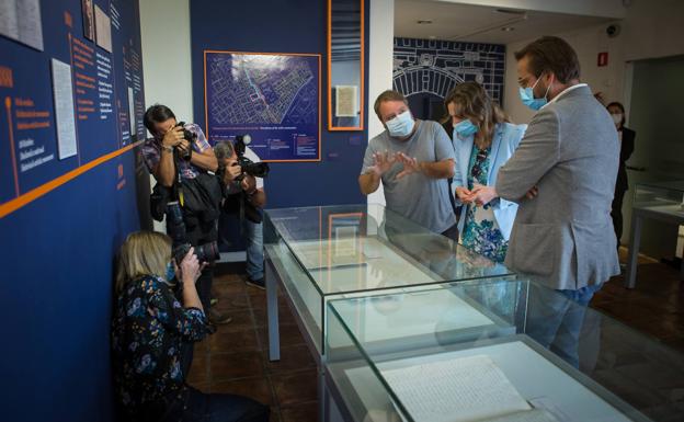 Ángel Rodríguez, comisario de la exposición, explica unos documentos a Rocío Díaz y Antonio Granados.