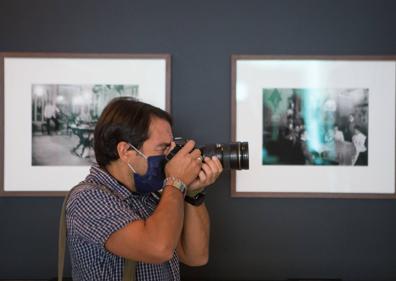 Imagen secundaria 1 - Arriba, observando uno de los paneles de la exposición. Debajo, fotógrafo en plena faena y la comisaria Lucía Laín mostrando el catálogo.