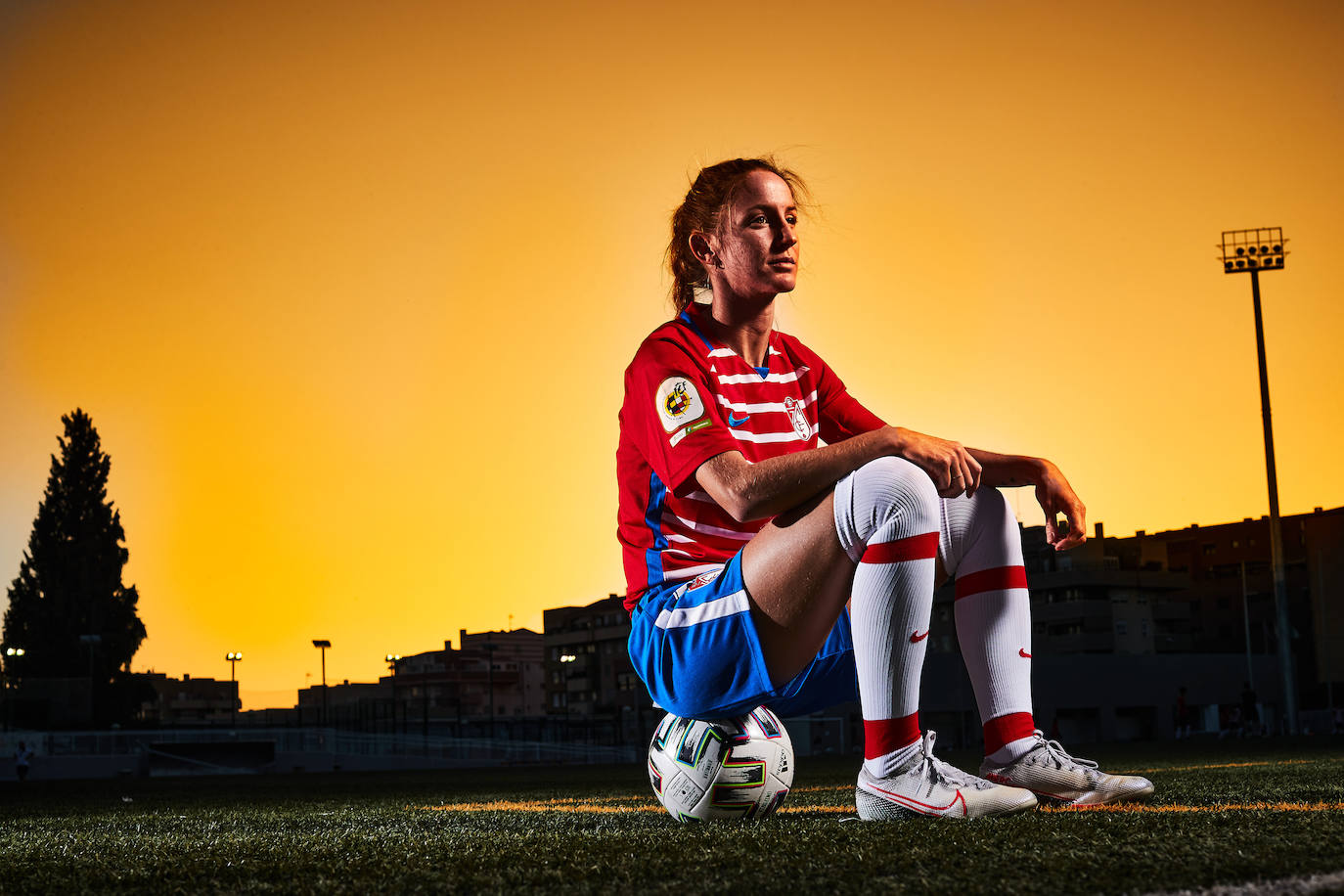 Lauri, mirada hacia el infinito, sentada sobre un balón en el Estadio de la Juventud. 