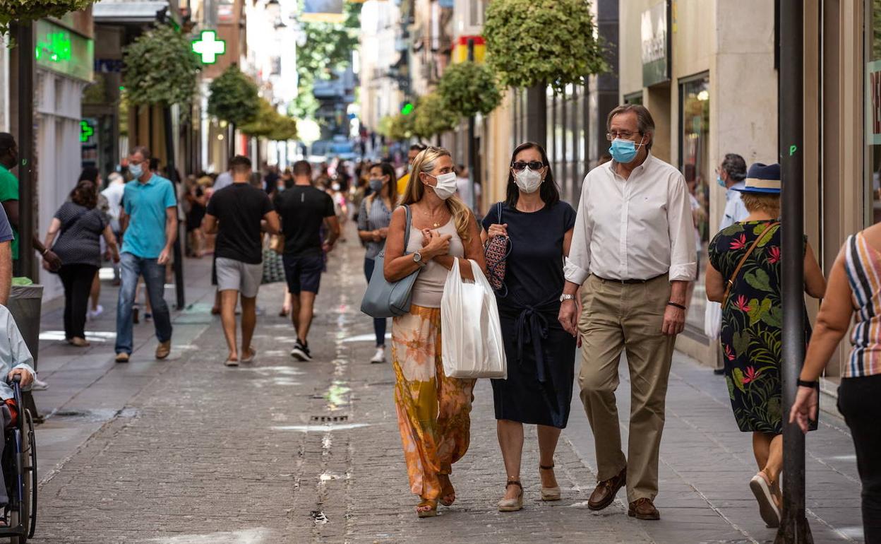 Un grupo de personas pasea con mascarilla por la capital granadina en una imagen de archivo. 