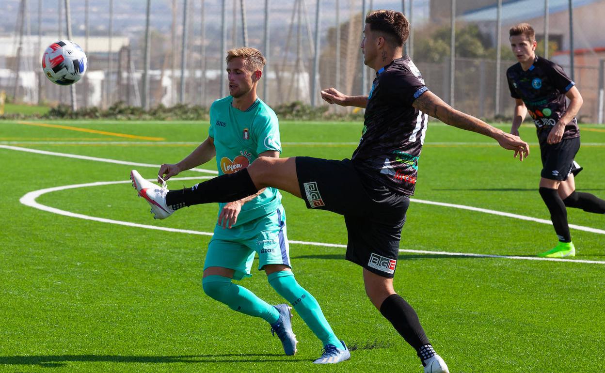 Leo Ramírez despeja el balón acosado por George Higgins. 