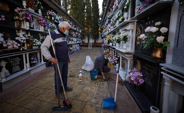 Dos señores, ayer limpiando un nicho en el cementerio de Maracena. 