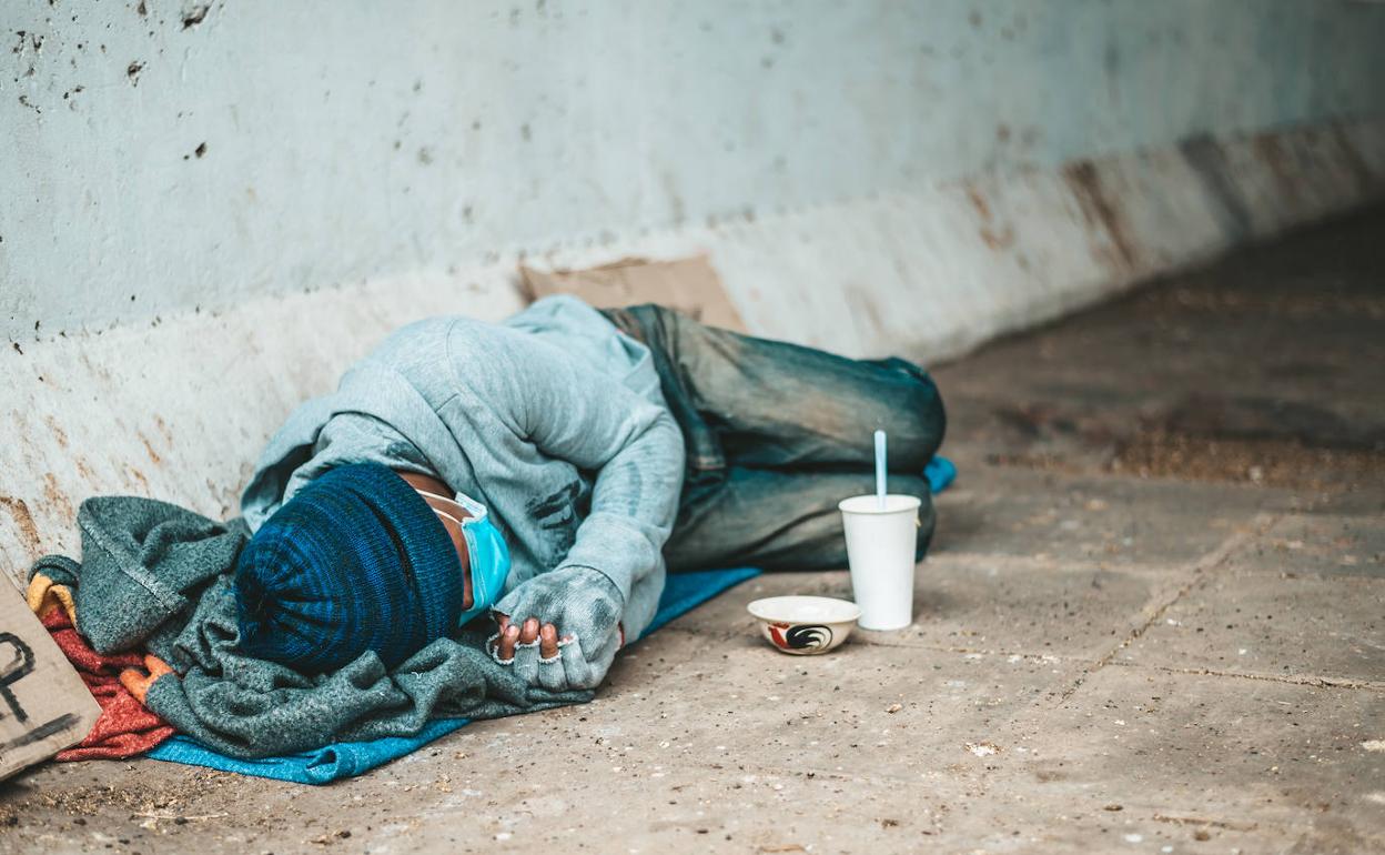 Una persona sin hogar duerme en la calle.