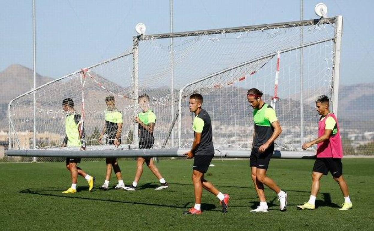 Los futbolistas del Recreativo Granada portan una portería durante un entrenamiento anterior. 