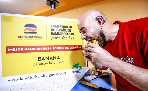 El ganador del concurso, Pablo Gómez, degusta una hamburguesa hecha por él.