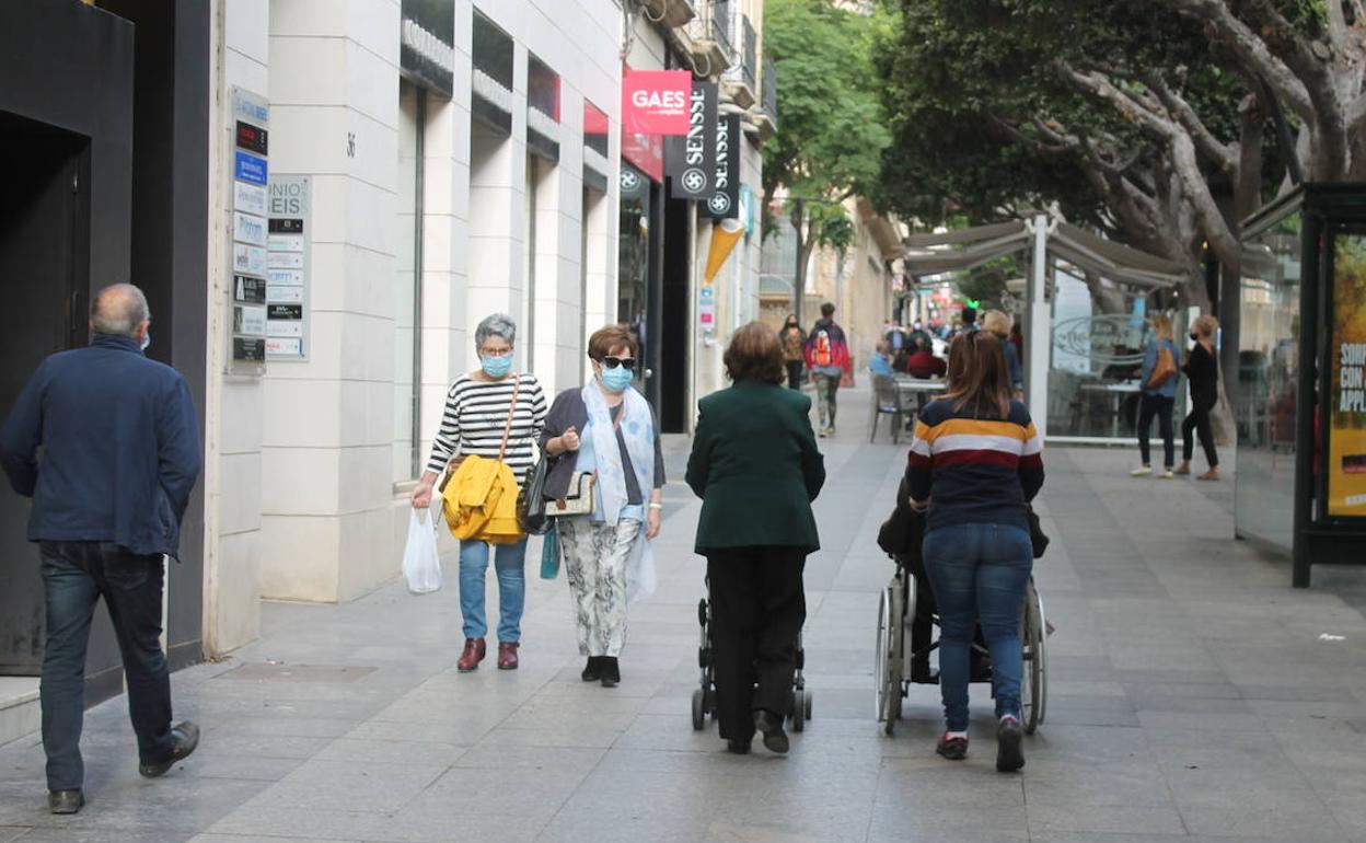 Viandantes, protegidos con mascarilla, caminan por el Paseo de Almería. 