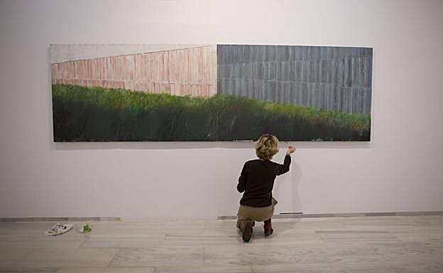 Sevilla retoca uno de los cuadros de su exposición 'Nuevas lejanías'. 