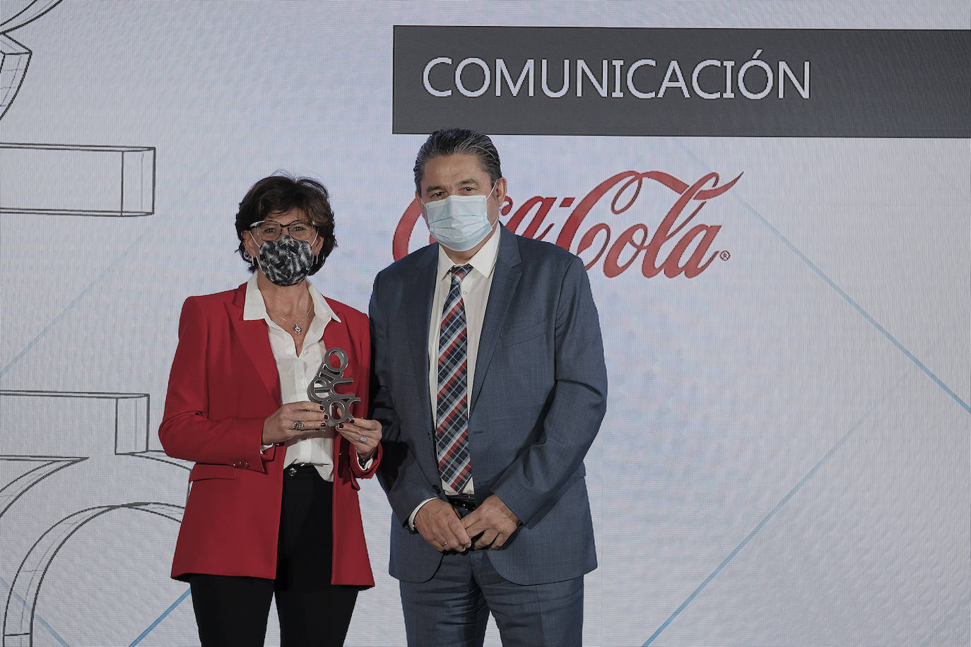 Óscar Campillo, director general de comunición y RRII de Vocento, entrega el premio a Sara Blázquez, directora de comunicación externa de Coca-Cola Iberia.