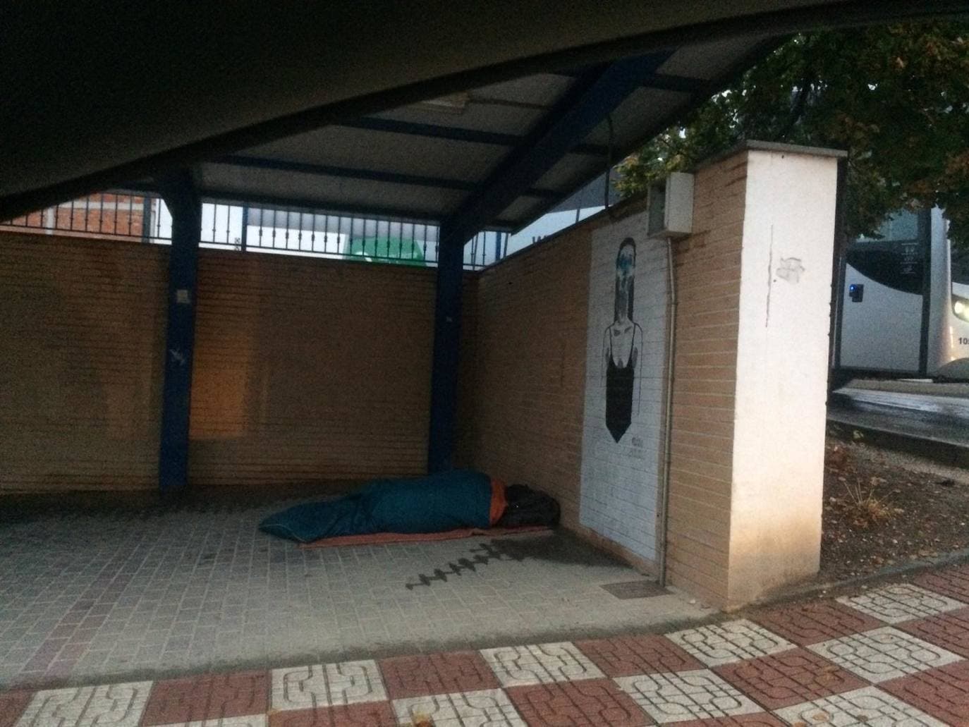 El hombre sin hogar durmiendo en la parada de taxis en Íllora. 
