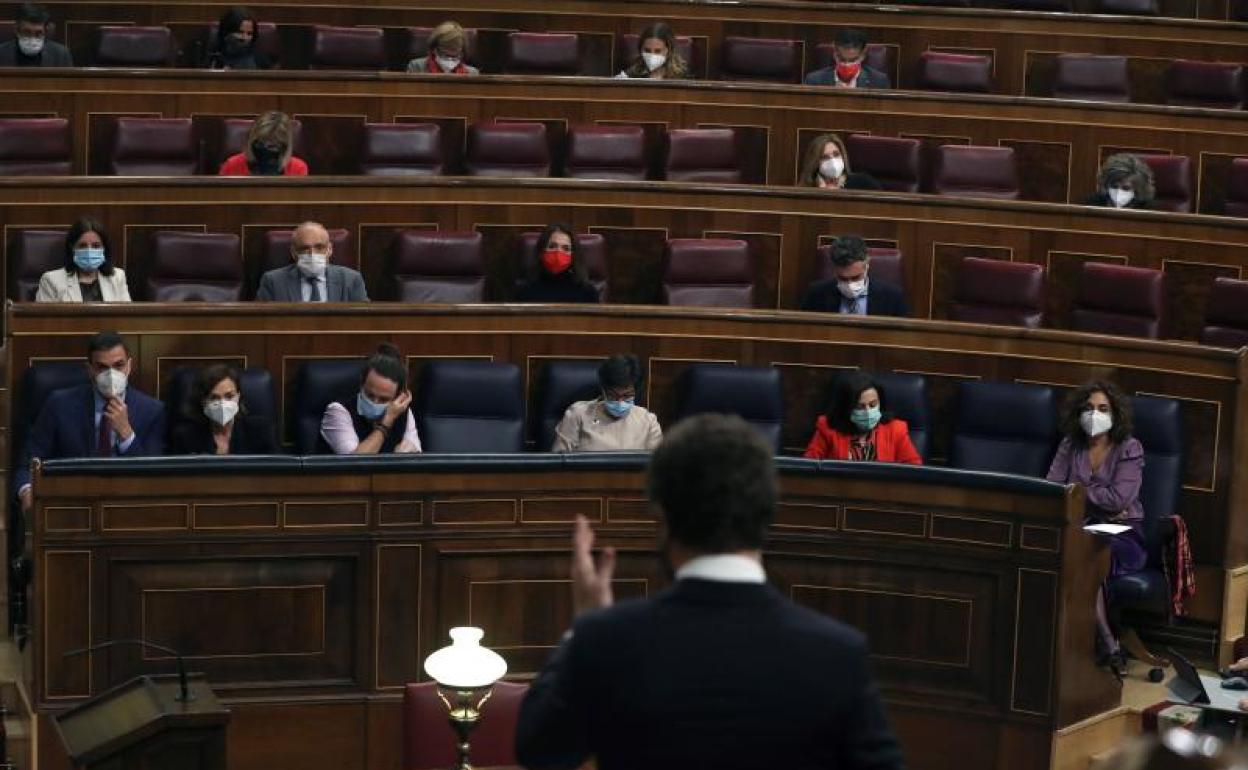 El presidente del PP, Pablo Casado (de espaldas) interviene durante el pleno del Congreso 