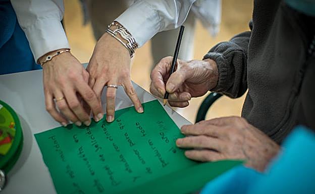 Una residente firma una felicitación de Navidad. 