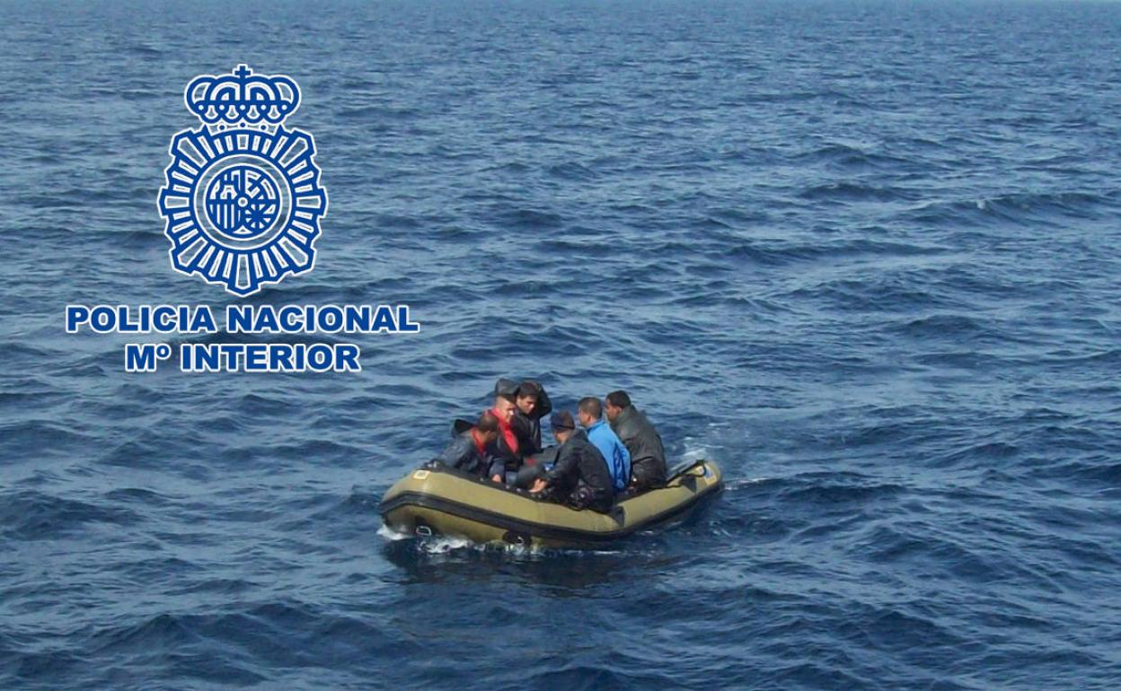 Un grupo de personas en una patera en alta mar. 