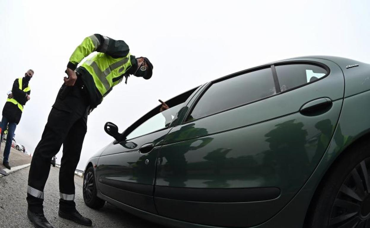 Un agente de la Guardia Civil pregunta a un conductor el motivo de su desplazamiento durante un control.