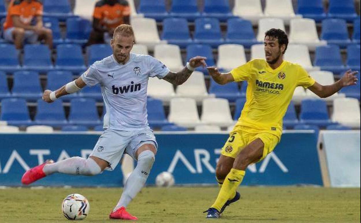 Uros Racic (izq) intenta dar un pase durante un amistoso entre el Valencia y el Villarreal. 