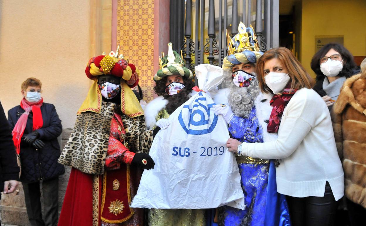 Sus Majestades recogen la saca con las cartas escritas por los niños. 