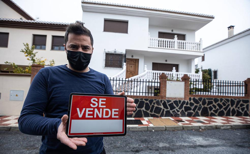 Ernesto Cabello sostiene un cartel de 'Se vende' frente a la casa de cuatro plantas en la que está el estudio de grabación diseñado por Harold Burgon. 