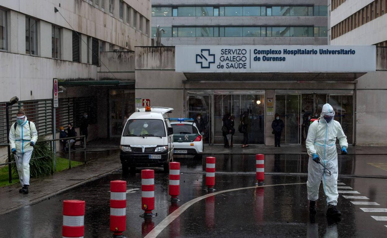 Empleados municipales desinfectan el acceso al Complejo Hospitalario Universitario de Ourense (CHUO).