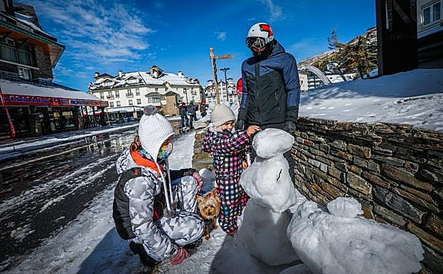 Carlota, de Moguer (Huelva), construye un muñeco de nieve junto a sus padres. 