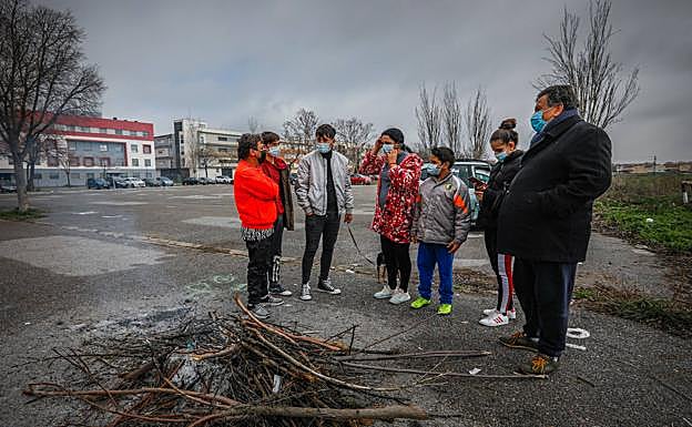Una de las familias conversa alrededor de las cenizas de la hoguera.