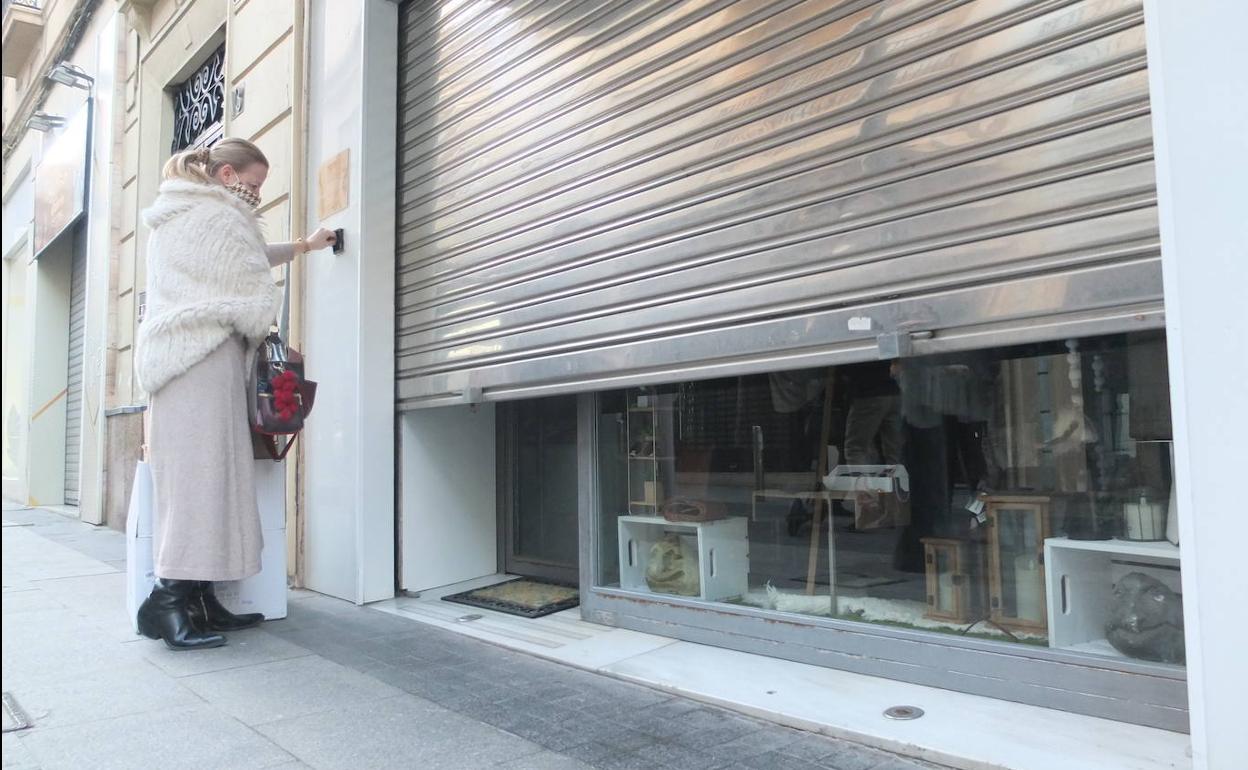Una comerciante de la capital bajando las persianas de su negocio el pasado martes, último día que pudo abrir.