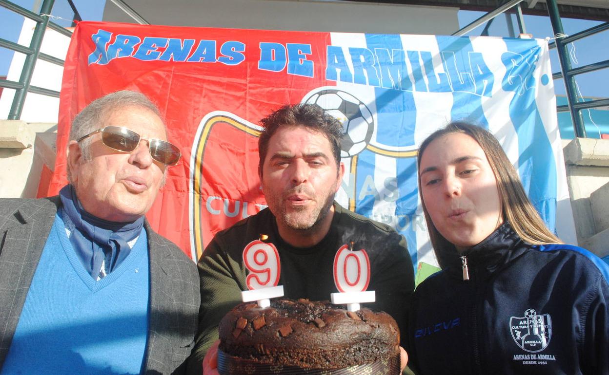 Antonio, socio más veterano del Arenas, el presidente de la entidad Fermín Criado y la futbolista Mela, soplan las velas del noventa aniversario de este club granadino.