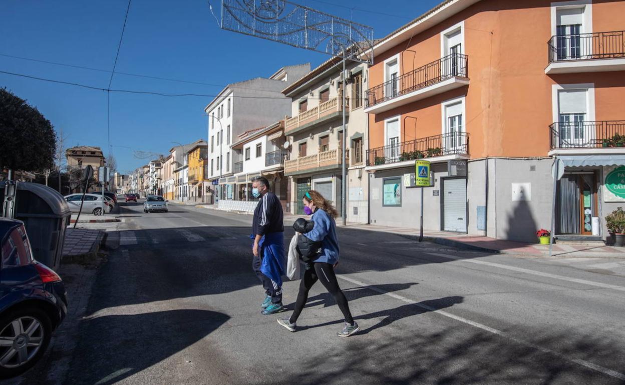 Dos personas cruzan una calle en Padul el día que se decretó el cierre. 