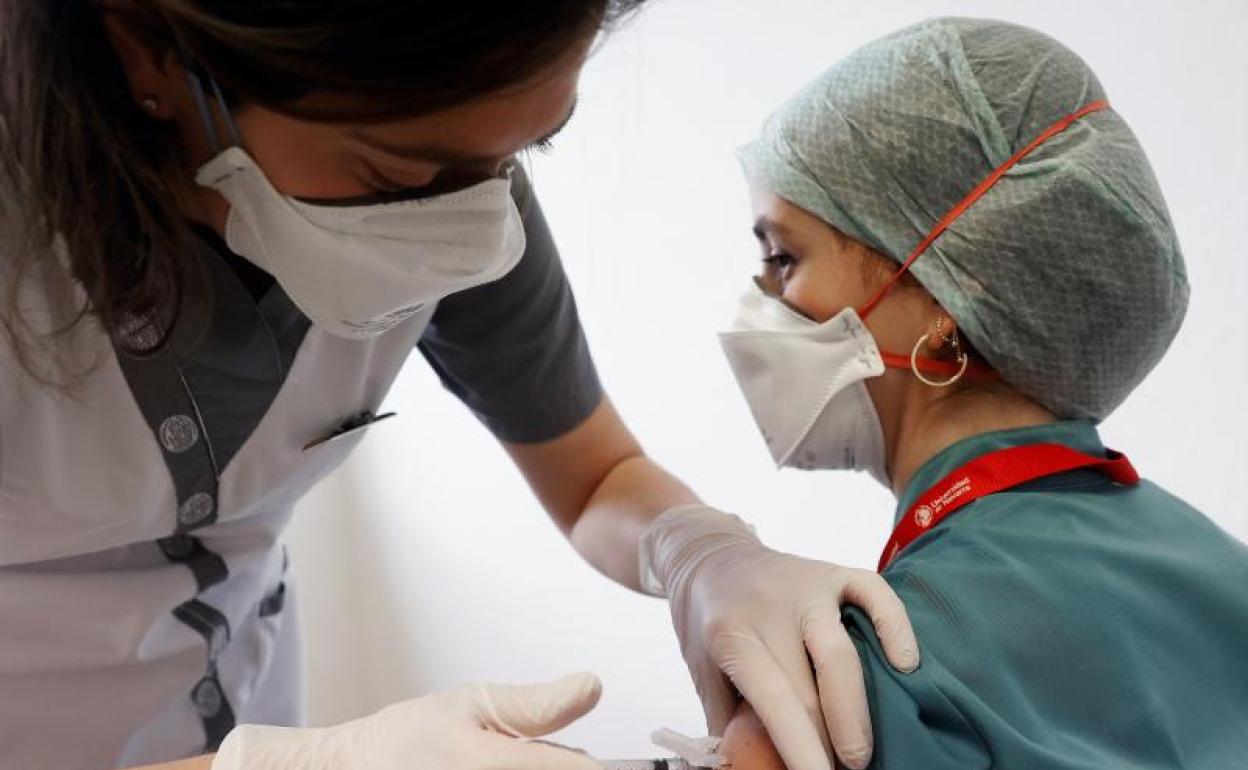 Una trabajadora sanitaria recibe la vacuna.