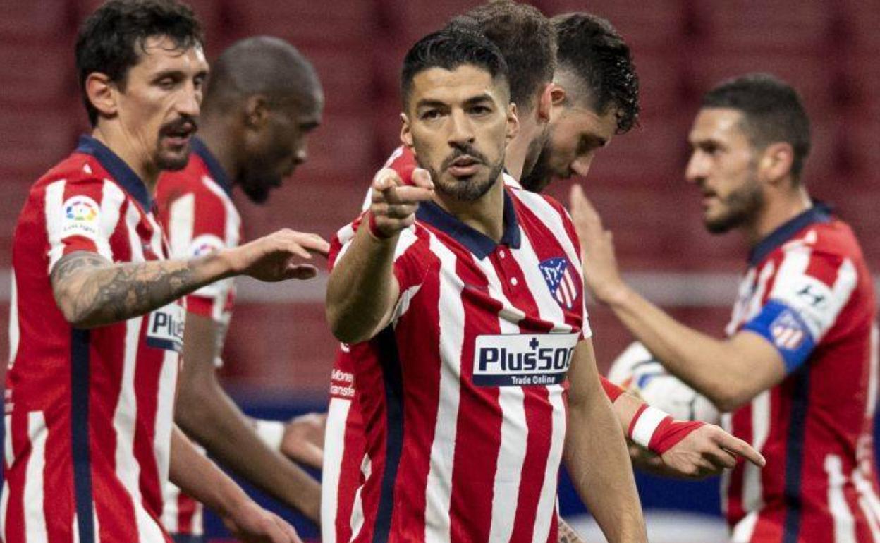 Luis Suárez apunta con su dedo a un título liguero que está en sus manos. 