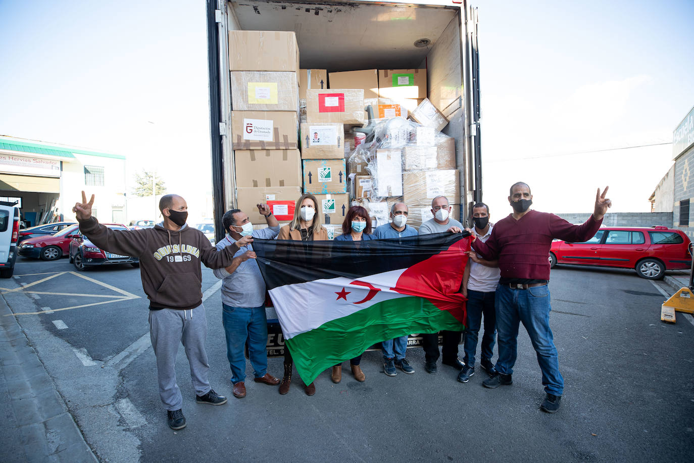Miembros de la asociación Amigos del Sáhara posan junto al camión cargado de paquetes para los niños. 